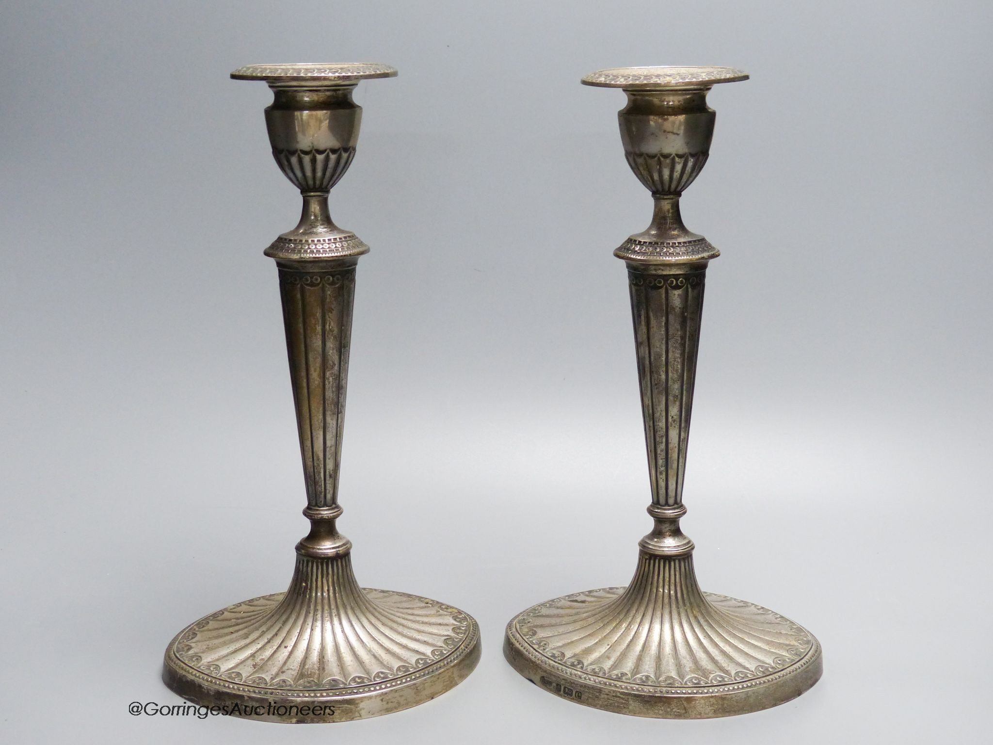 A pair of Edwardian silver candlesticks, by Elkington and co, Birmingham 1904, loaded, 28.5 cm high